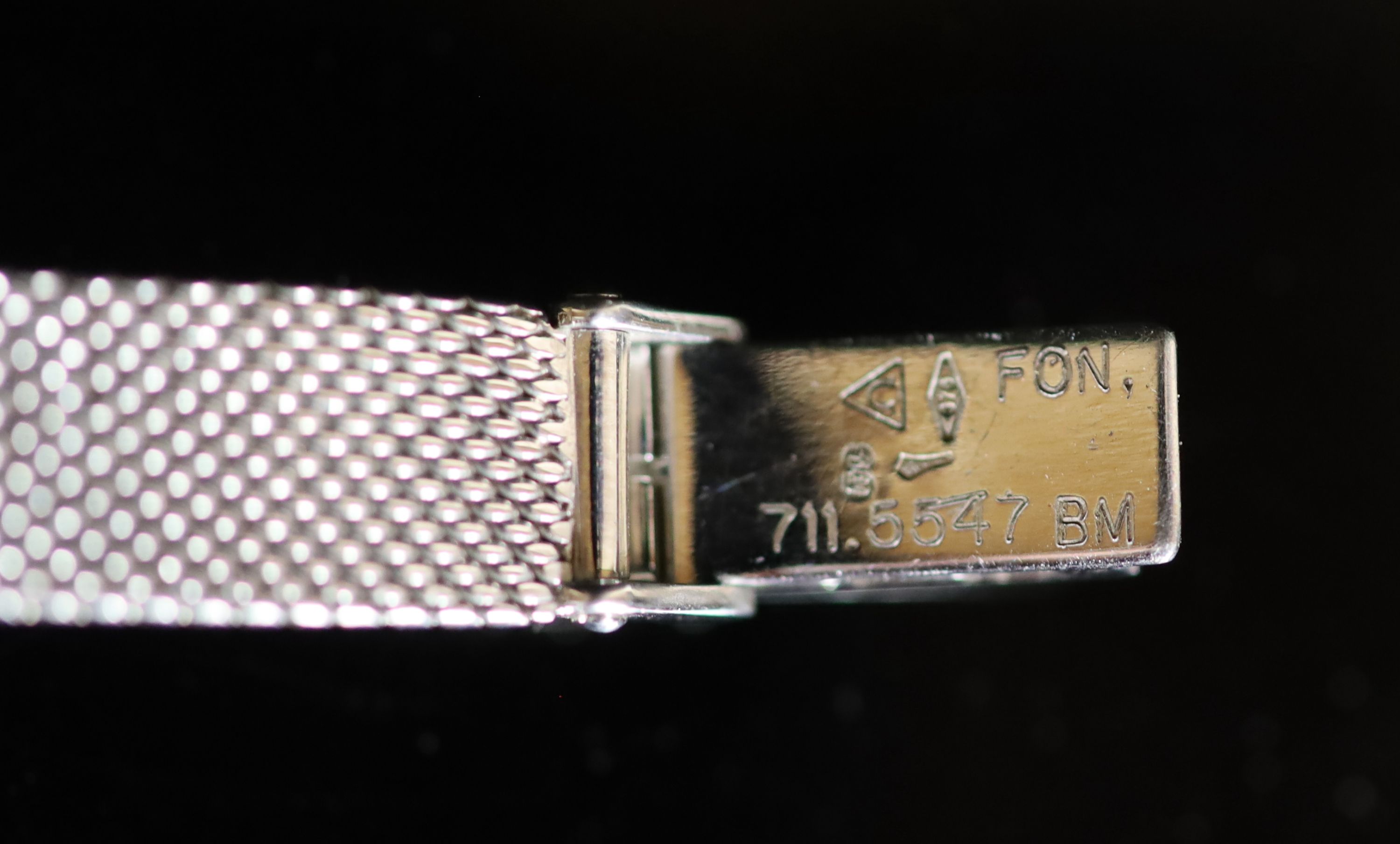 A lady's modern 9ct white gold Omega manual wind wrist watch, on an integral Omega 9ct white gold bracelet